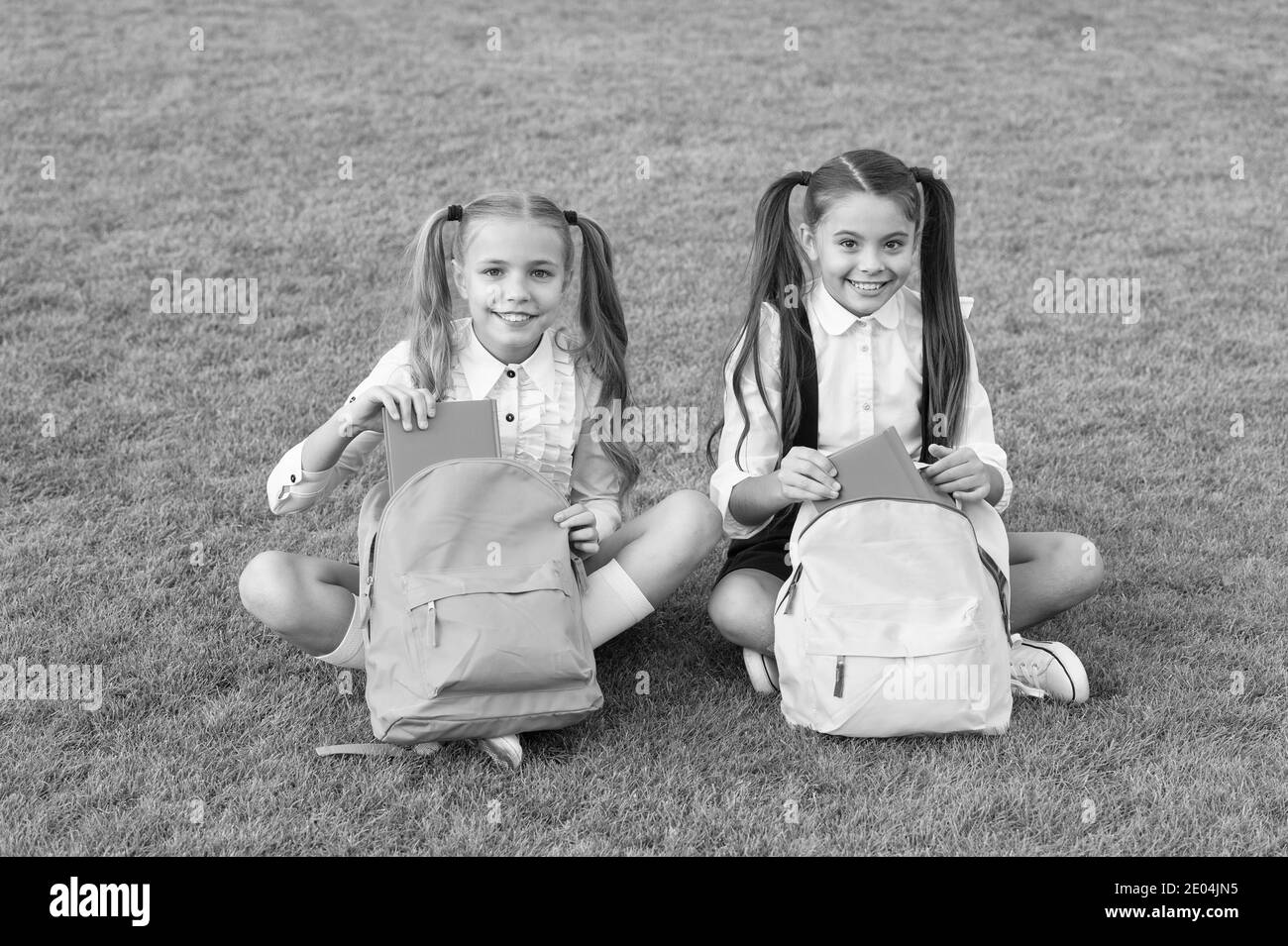 Now pick one. Happy kids do literature homework outdoors. Little friend with books green grass. Literature education. Literature and language. School library. Study and education. English literature. Stock Photo