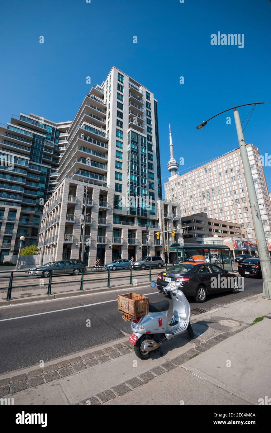 A Vespa motorcyle scooter parked on the side of Queens Quay in the lakeside Harbourfront area of Toronto Canada Stock Photo