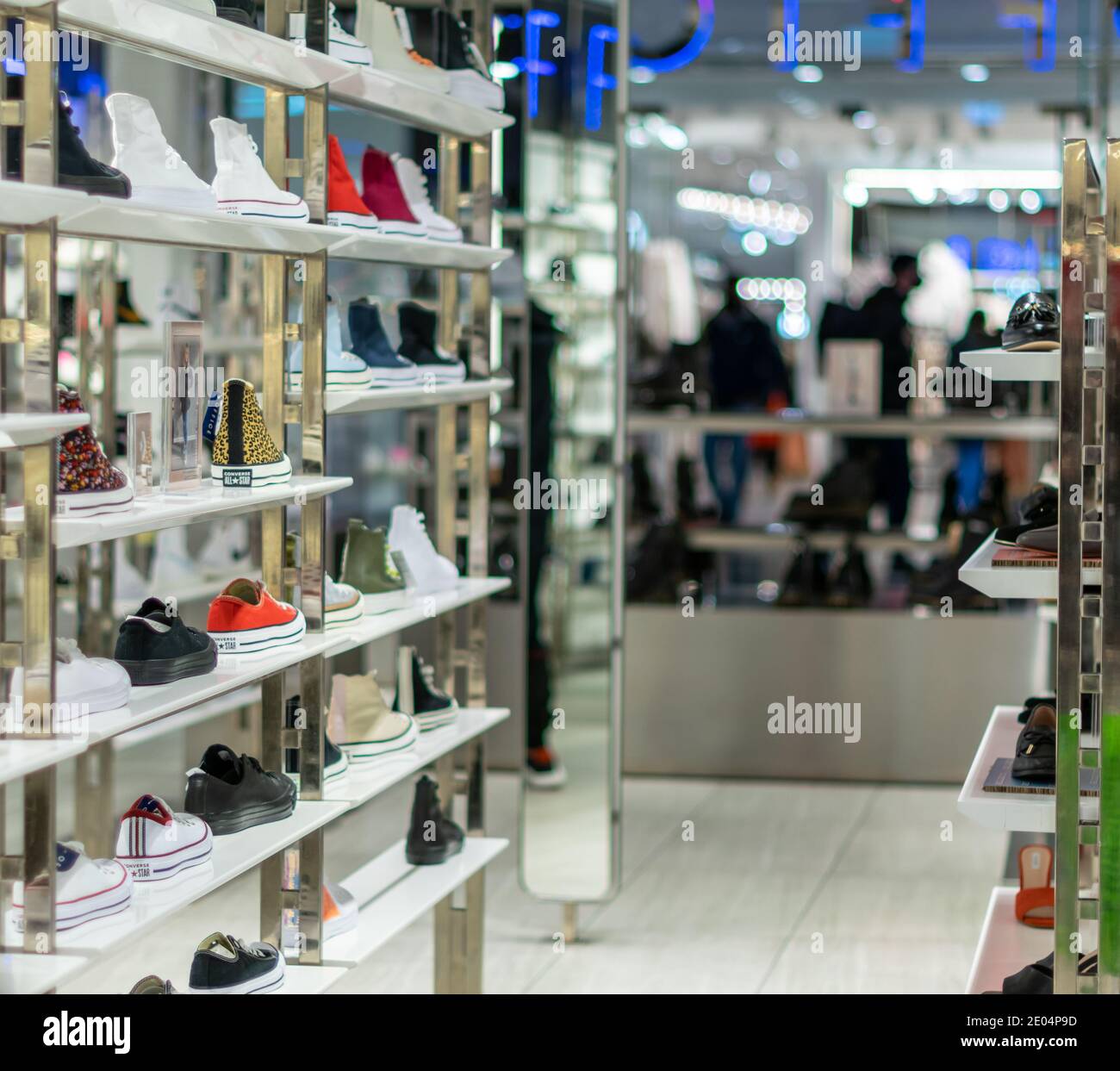 Oxford, UK -14 Dec 2020: Office shoe shop interior with converse trainers on shelfs in popular shopping centre, view for entrance from the inside of Stock Photo