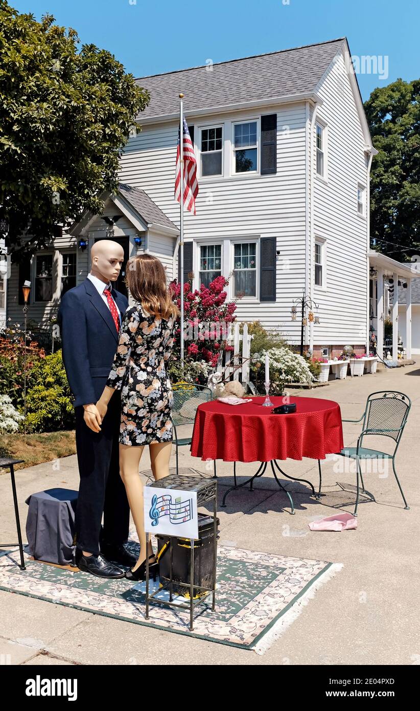 A mannequin couple looks longingly at each other as they dance in a driveway in the age of the Coronavirus. Stock Photo