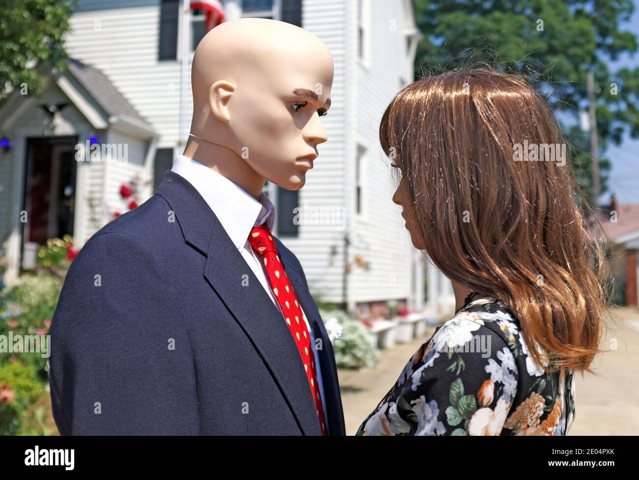 A couple of mannequins look lovingly into each other eyes as he sports a red valentines day tie. Stock Photo