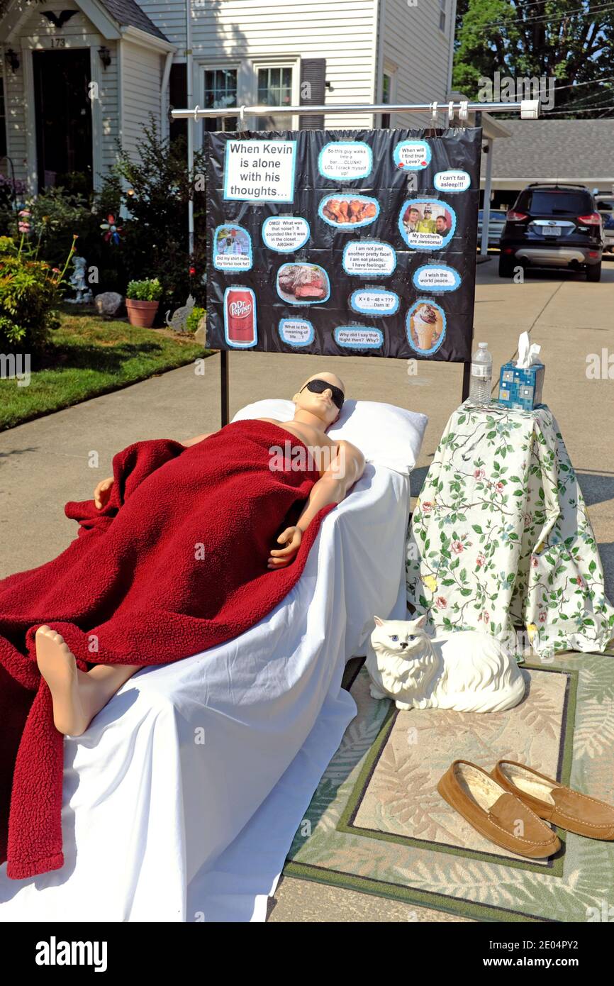 Kevin the mannequin is the central figure in a changing driveway diorama, sleeps with his dreams posted on the board behind him. Stock Photo