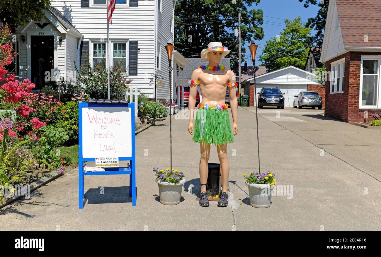 Kevin, the mannequin, is dressed in a luau skirt and hat with no shirt.  The driveway diorama changes daily entertaining neighbors and visitors. Stock Photo