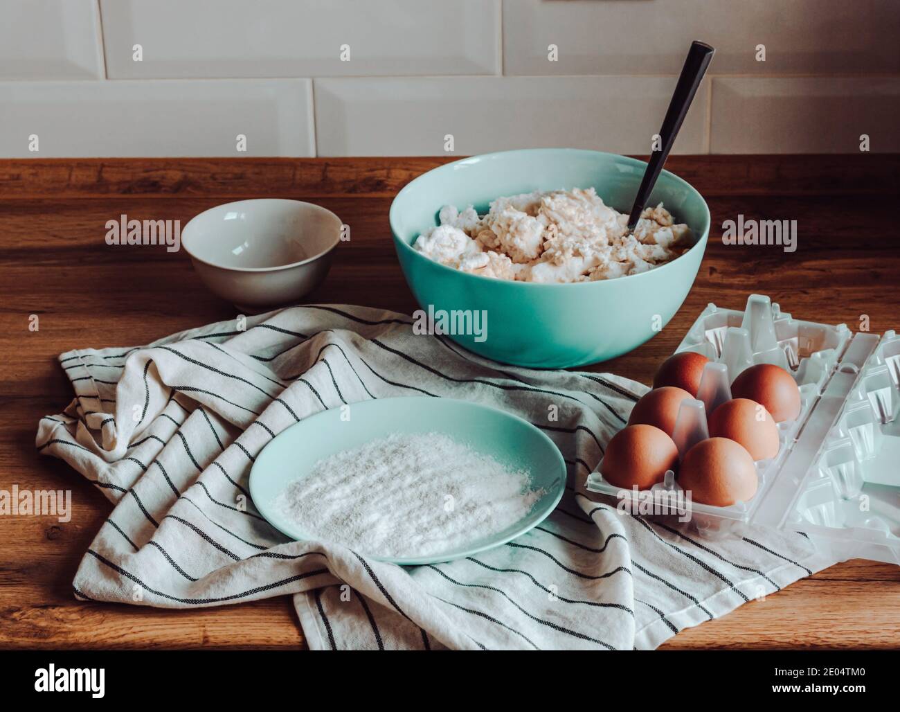 Cooking at home process illustrating pancakes pastry preparation in the modern wooden kitchen. Organic farm eggs, flour and cottage cheese ingredients Stock Photo