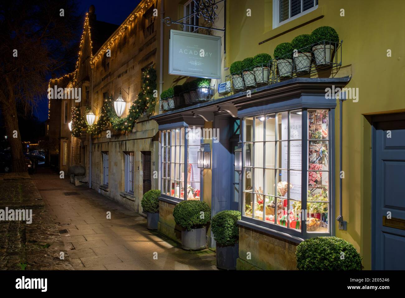 The Covent Garden Academy of Flowers along the high street with christmas lights at dawn. Chipping Campden, Cotswolds, Gloucestershire, England Stock Photo
