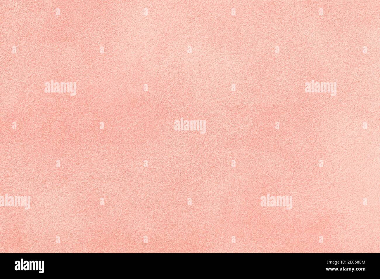 Light pink matte background of suede fabric, closeup. Velvet texture of