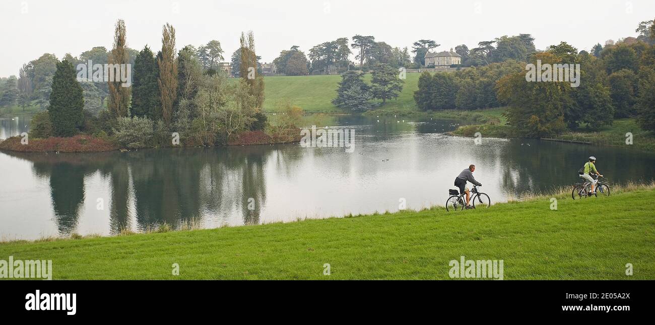 GREAT BRITAIN / England /Blenheim Palace/Couple riding bikes outdoors. Two peopel cycling at lake near Blenheim Palace, Woodstock,UK. Stock Photo