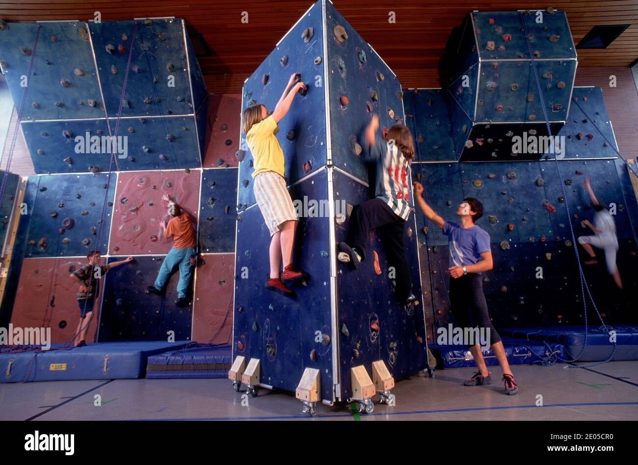 Happy kids climbing at an indoor climbing centre wall Stock Photo