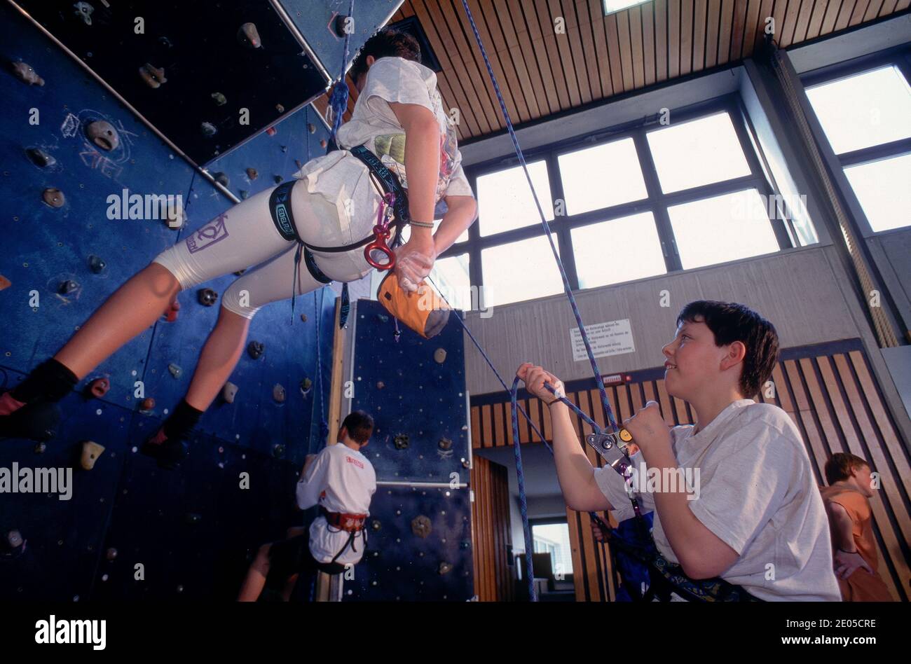 Boys climbing at an indoor climbing centre wall Stock Photo