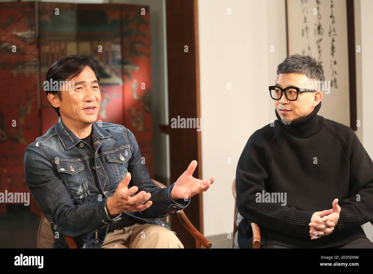 --FILE--Hong Kong actor and singer Tony Leung Chiu-wai, left, shows up at a local talk show and promotes his new movie The Hunting, Shanghai, China, 2 Stock Photo