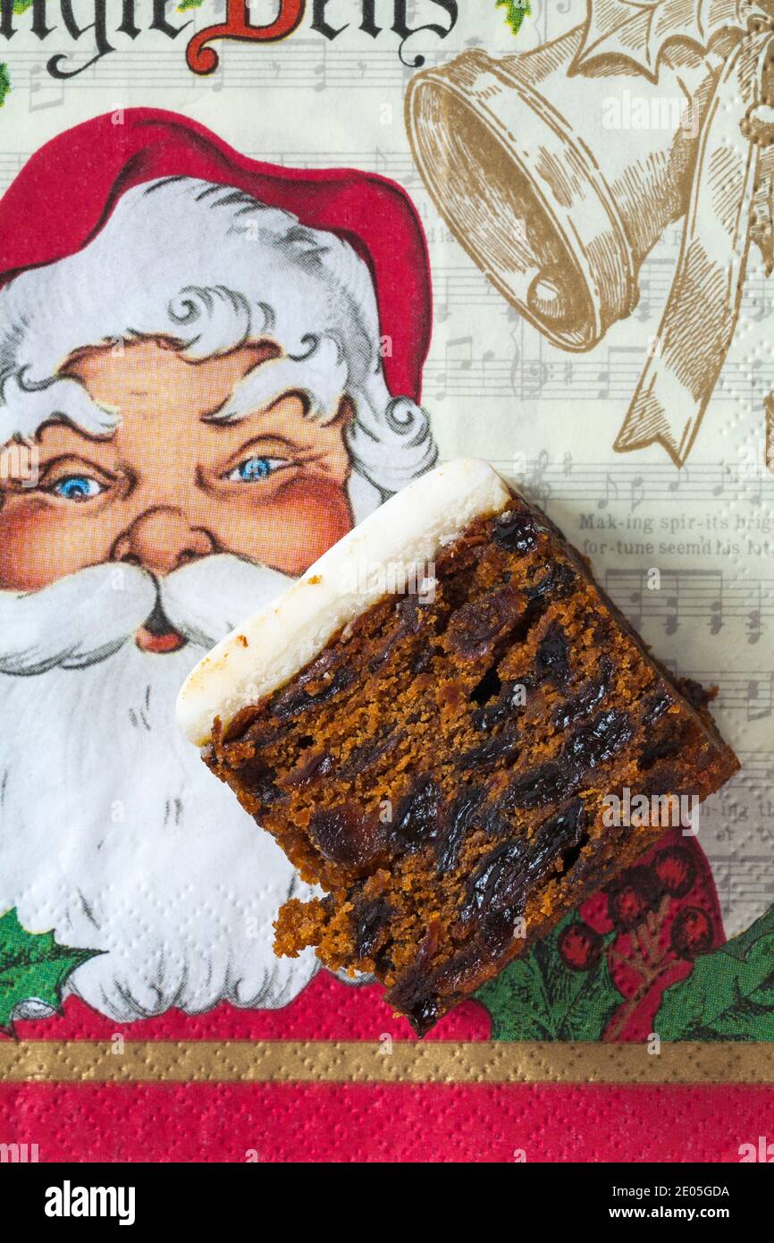 Slice of M&S Iced Fruit Cake Christmas Cake set on Christmas serviette napkin - UK festive Xmas Stock Photo