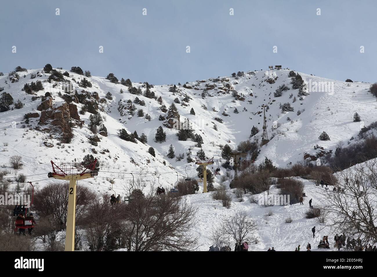 Cable car with people in winter in the Chimgan mountains, the mountains are covered with snow Stock Photo