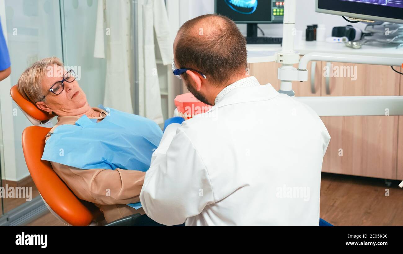 Specialist orthodontist holding the dental jaw speaking with patient