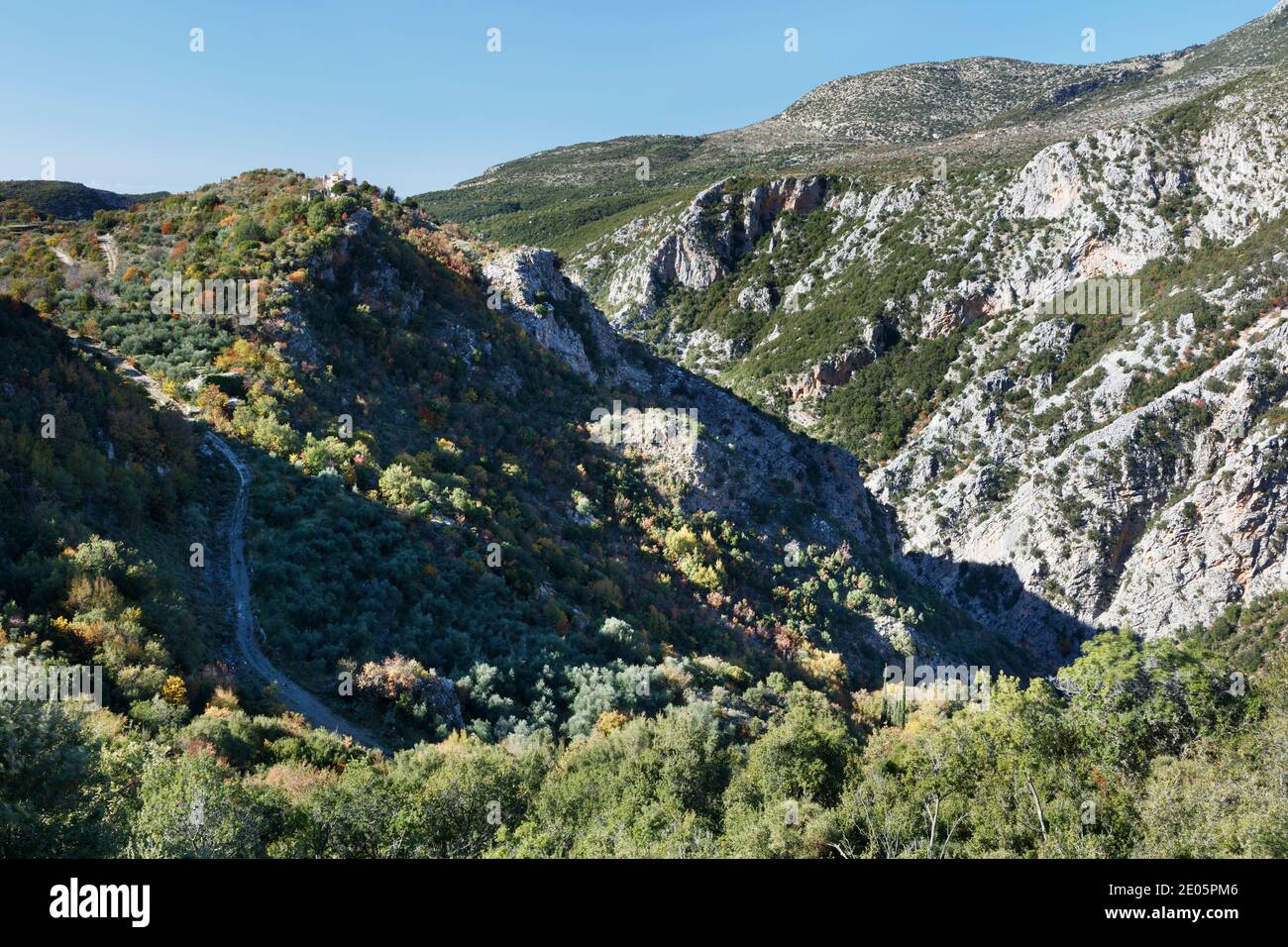 Profitis Ilias Monastery on the rim of the Rindomo Gorge in the Mani of Greece with Altomira village in the distance Stock Photo