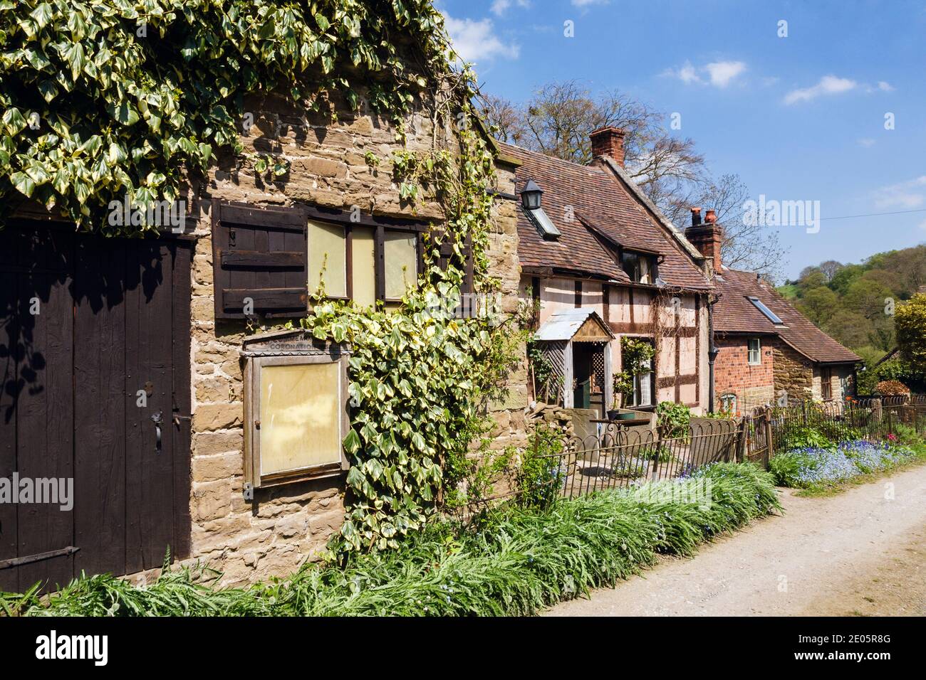 Quaint old cottage and outbuilding on country lane in rural village of