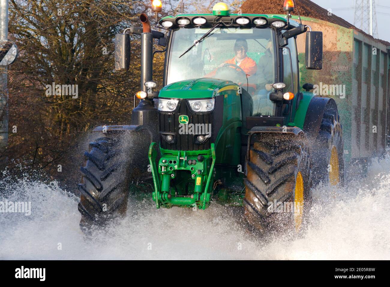 A tractor driving through Storm Bella floods on Barnsdale Road in