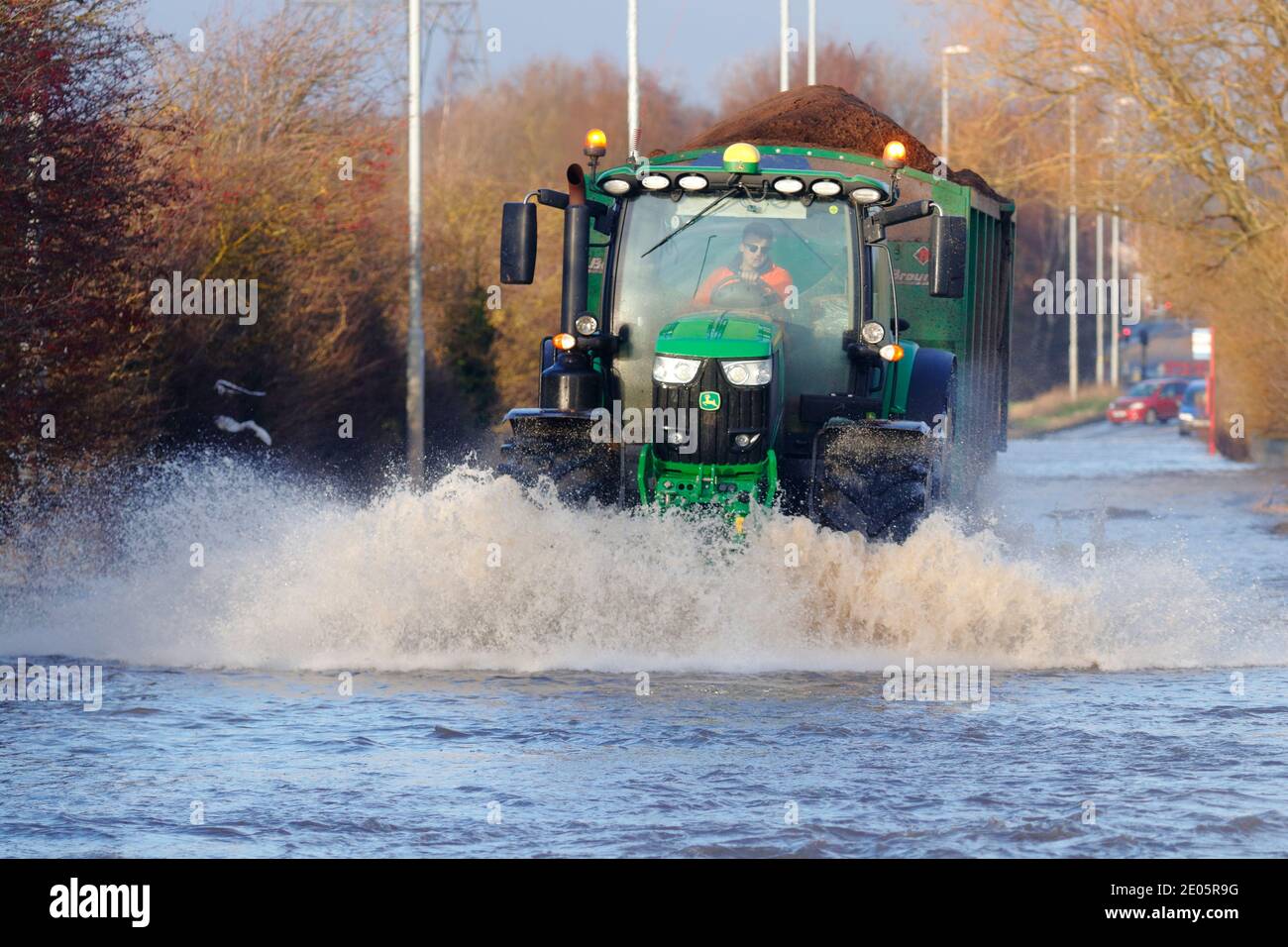 A tractor driving through Storm Bella floods on Barnsdale Road in