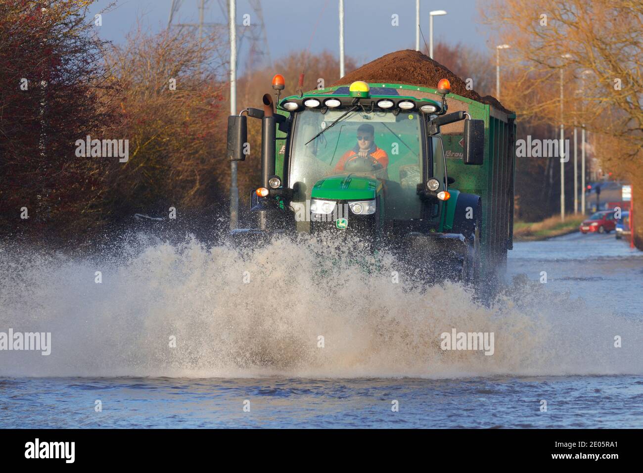 A tractor driving through Storm Bella floods on Barnsdale Road in