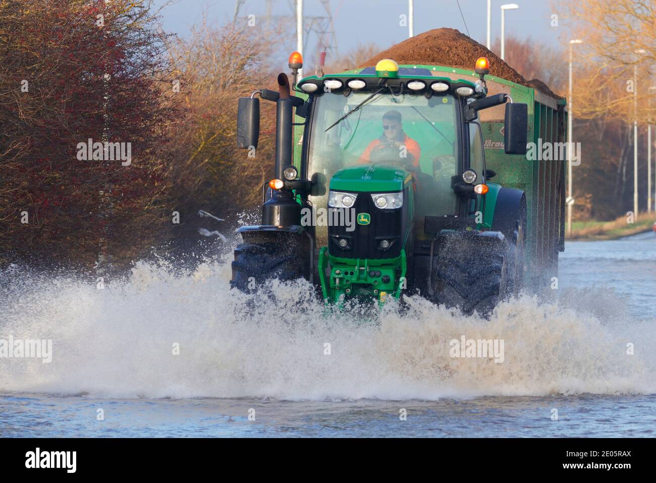 A tractor driving through Storm Bella floods on Barnsdale Road in