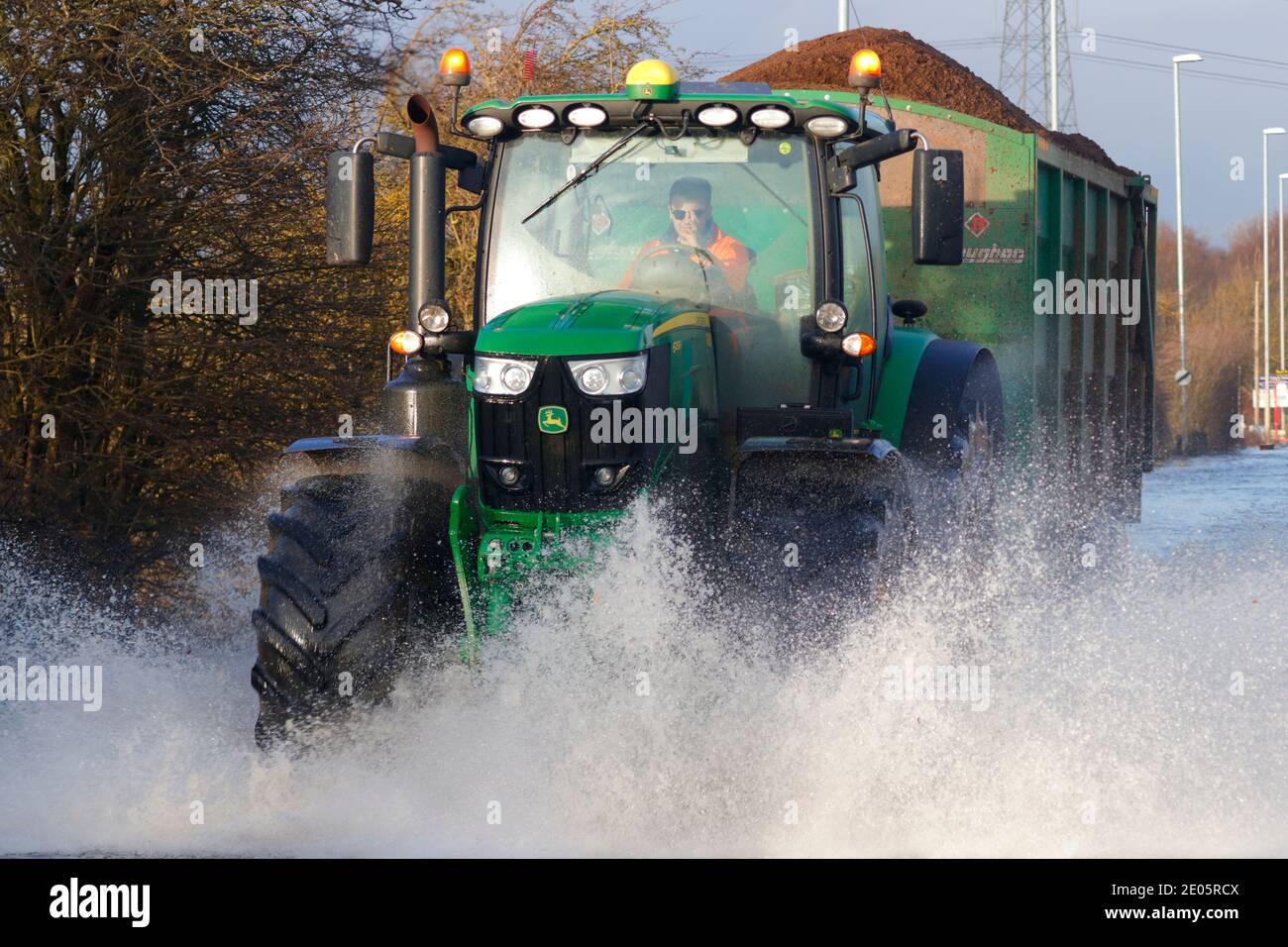 A tractor driving through Storm Bella floods on Barnsdale Road in
