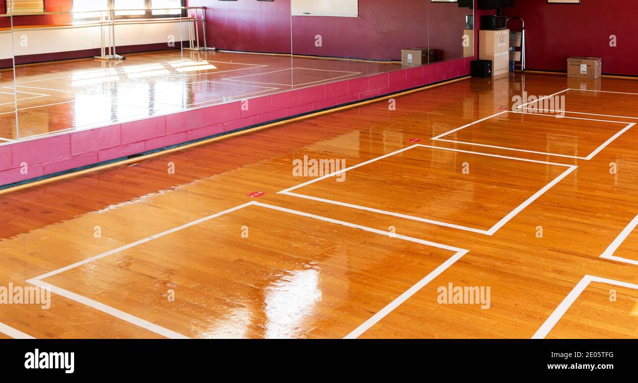 White taped boxes on the floor of a high school dance studio to help keep the students six feet apart because of covid-19 coronavirus pandemic. Stock Photo