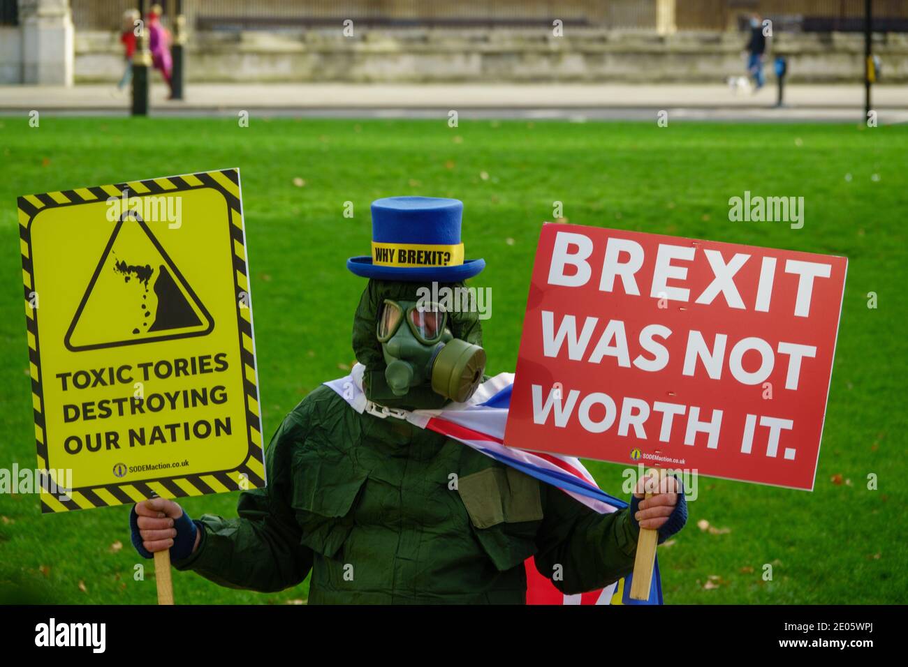 Steve Bray, Mr Stop Brexit, a pro-EU protester, wearing a gas mask and CBRN suit. He holds placards stating Tories Toxic and Brexit Not Worth It as MPs debate EU Trade Deal in House of Commons after Parliament was recalled from Christmas recess (30th December 2020). Parliament voted to pass the EU-UK Trade deal and the UK exited the EU fully on 1st January 2021. Stock Photo