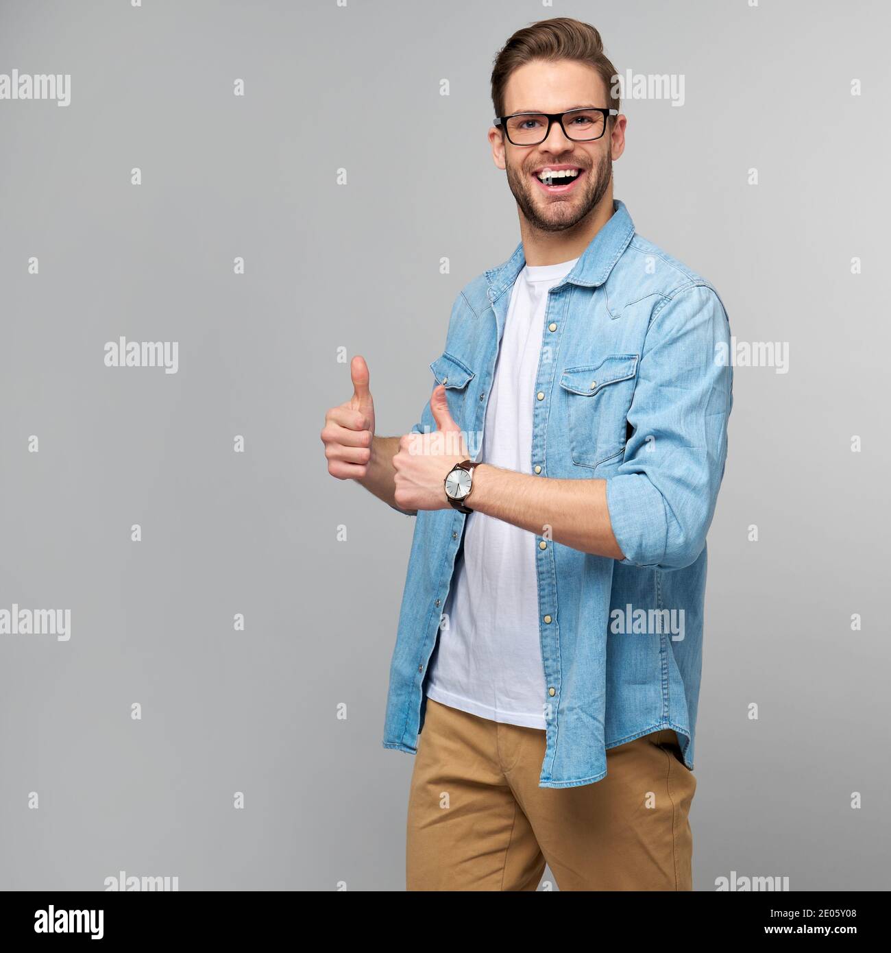 Portrait of young handsome caucasian man in jeans shirt showing big ...