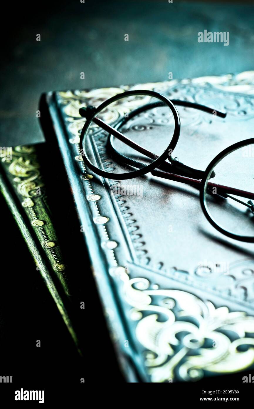 two old books stacked and reading glasses Stock Photo
