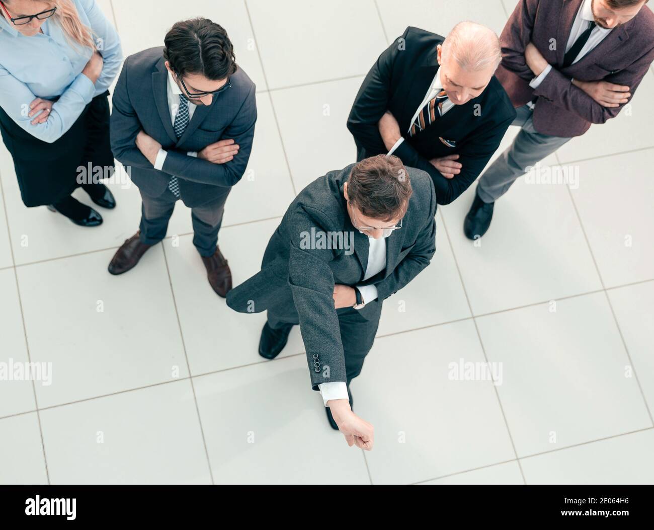 project Manager standing in front of his team and giving a thumbs up ...