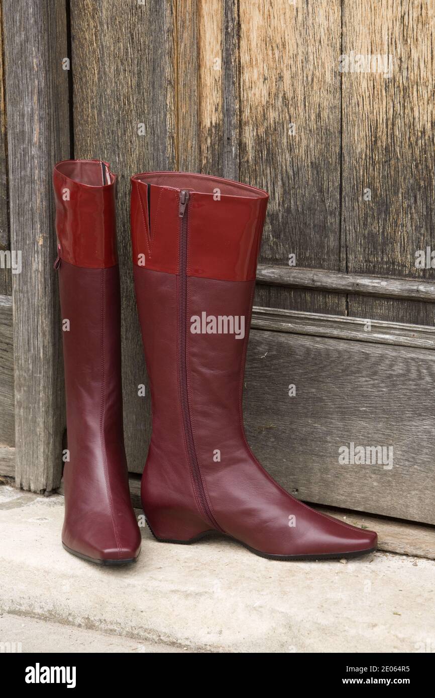 Ladies reddish brown leather boots standing on front door step Stock Photo