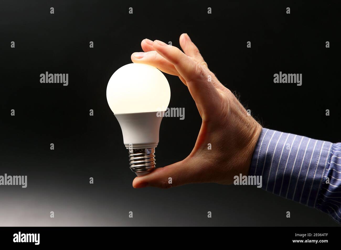 human hand holding the included led lamp on a dark background Stock ...