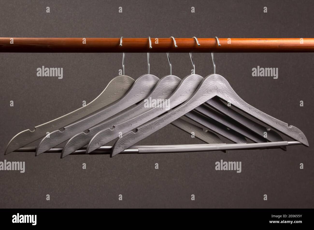 Empty clothes hanger hanging on a green background. Accessories and