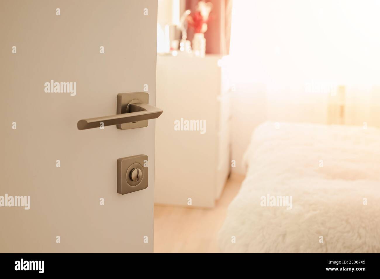 Opened door with metal knob close-up Stock Photo