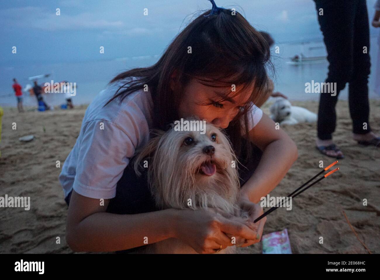 Denpasar, Bali, Indonesia. 30th Dec, 2020. A woman and her dog lights