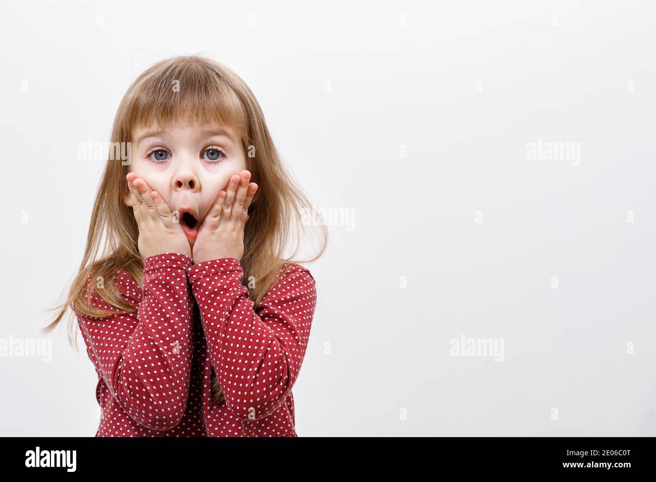 little girl surprised, hands on her cheeks. mock up with copy space ...
