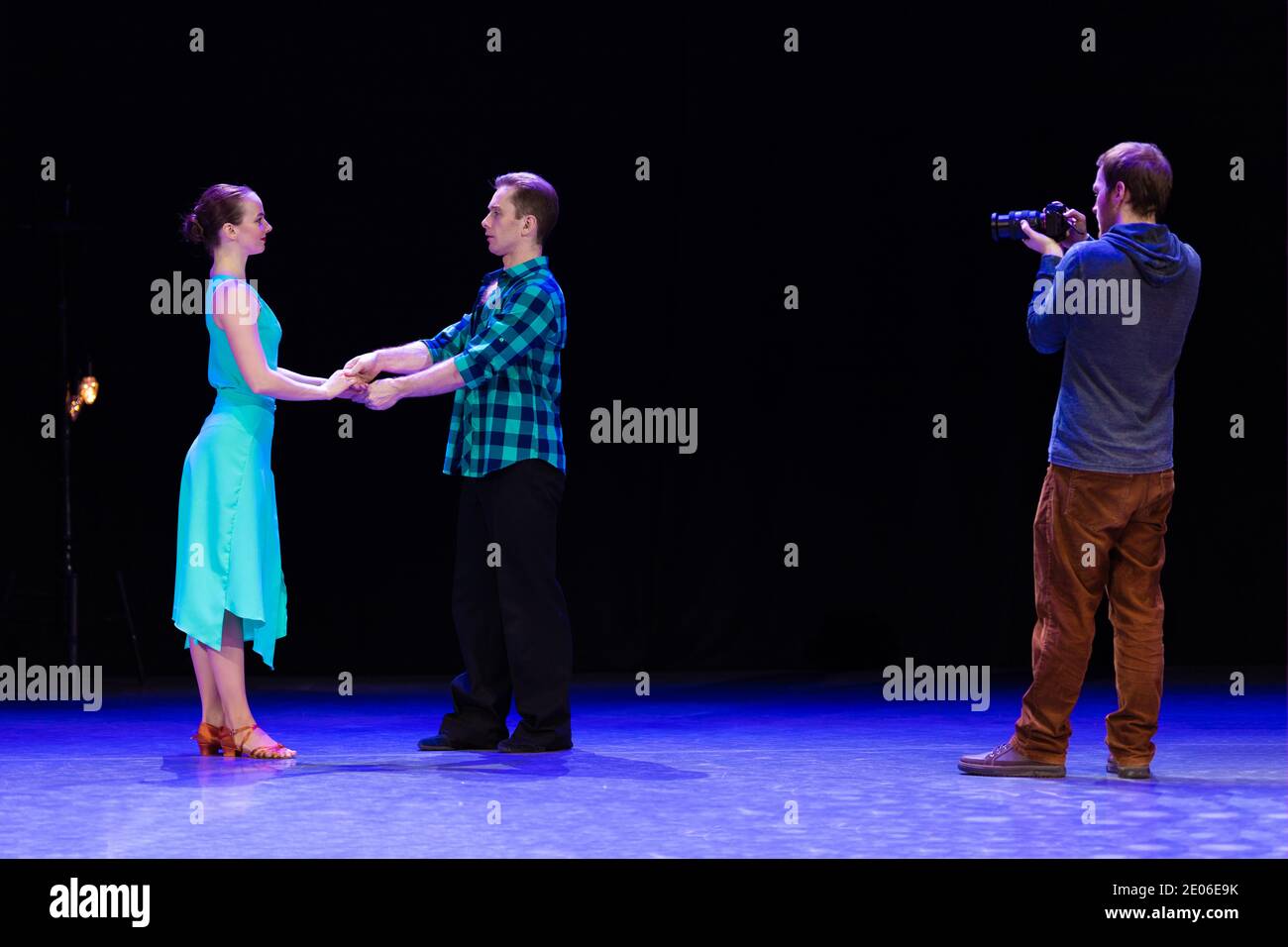 A pair of dancers a man and a woman are dancing on stage and a man  videographer records a video clip and reports Stock Photo - Alamy