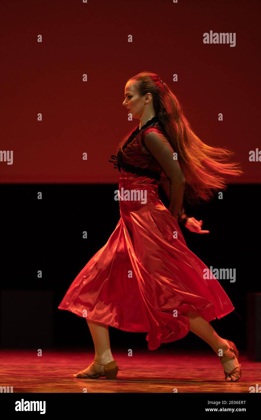 Dancer in a red dress dancing Spanish flamenco on the stage in the ...