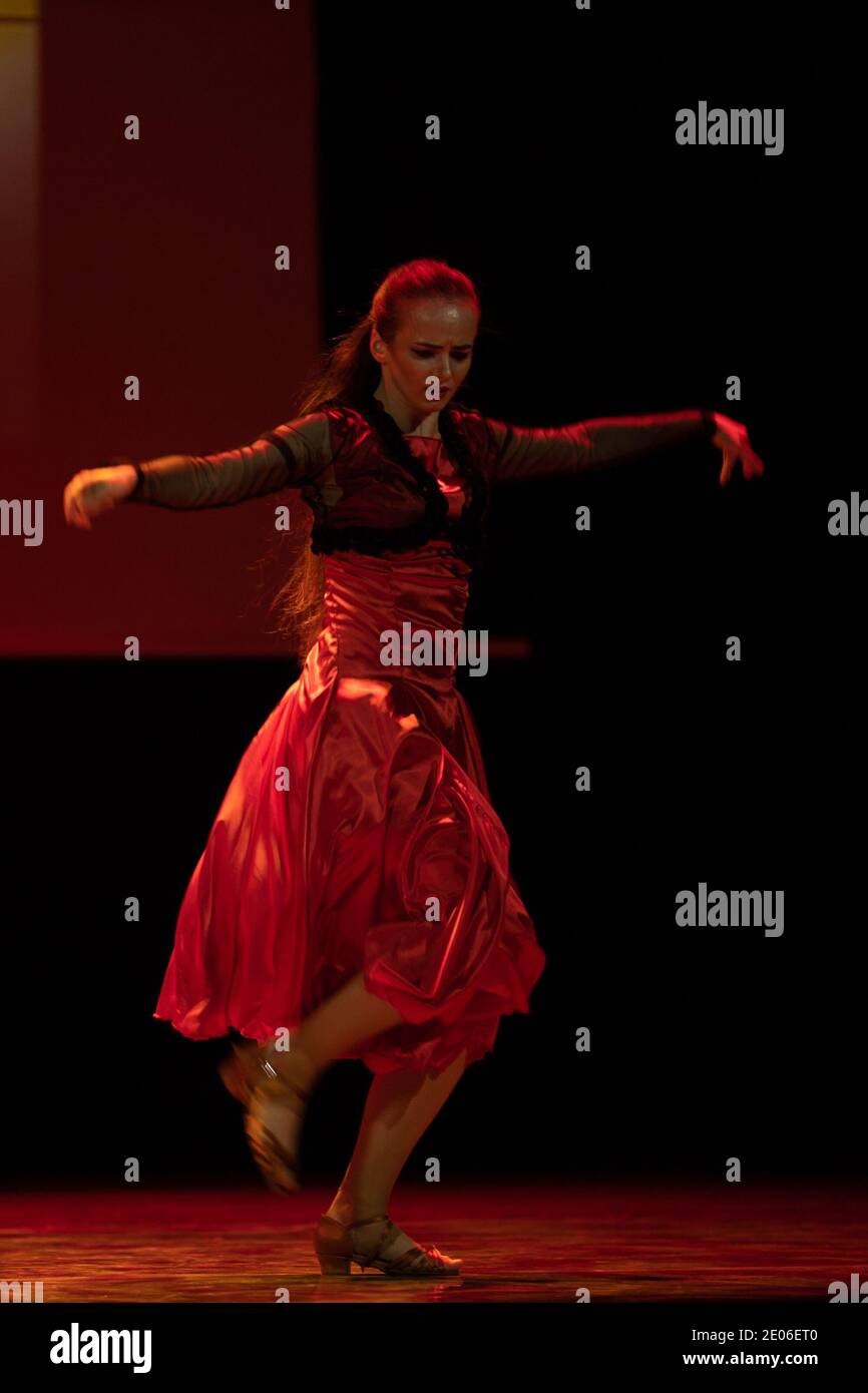 Dancer in a red dress dancing Spanish flamenco on the stage in the ...