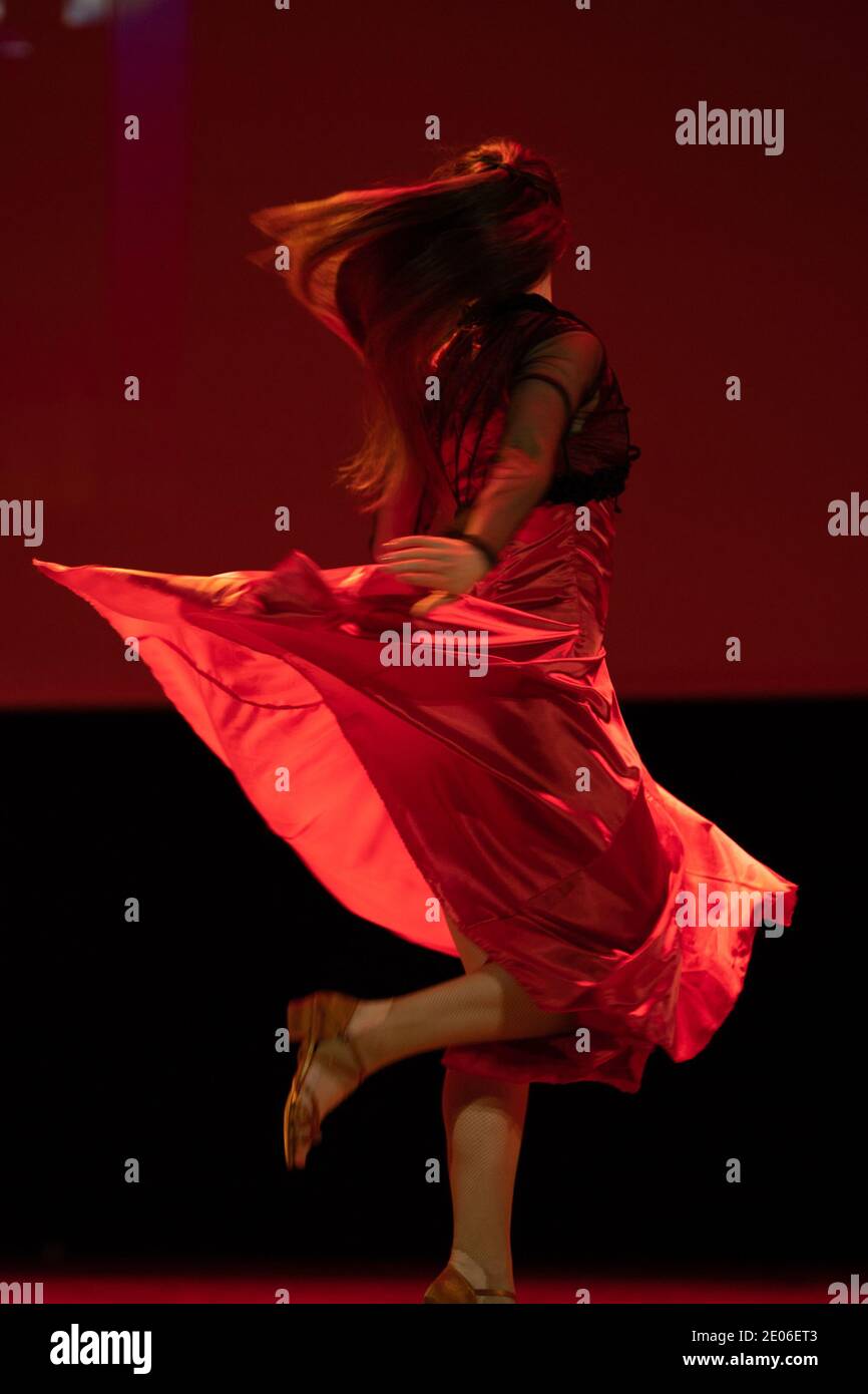 Dancer in a red dress dancing Spanish flamenco on the stage in the ...