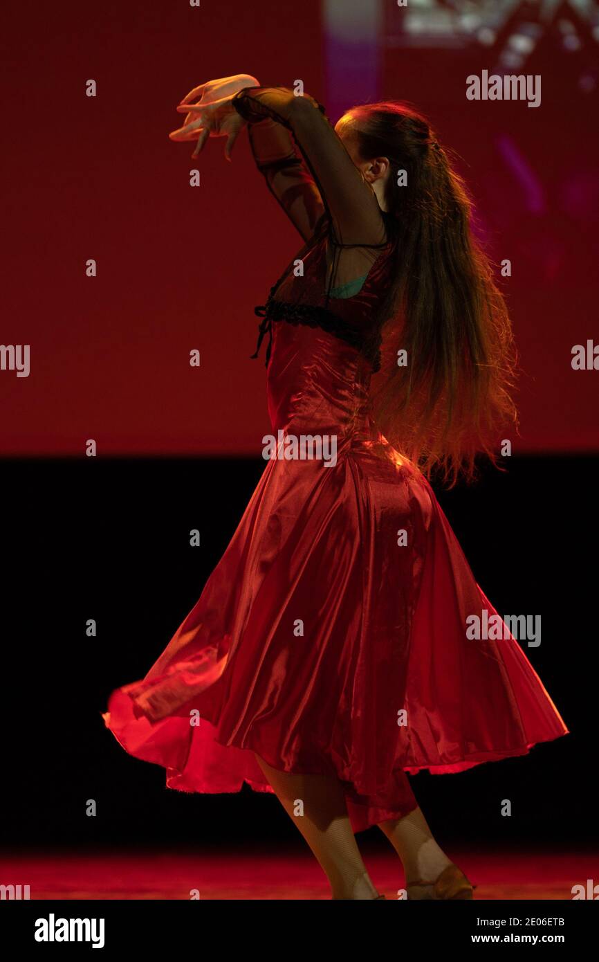 Dancer in a red dress dancing Spanish flamenco on the stage in the ...