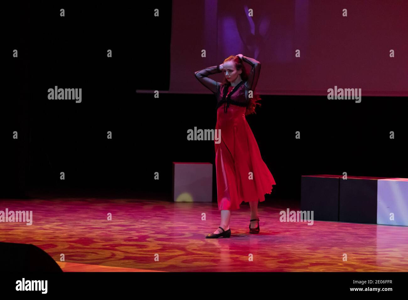 Dancer in a red dress dancing Spanish flamenco on the stage in the ...
