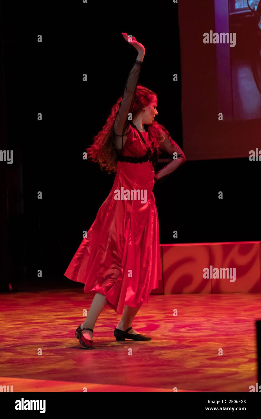 Dancer in a red dress dancing Spanish flamenco on the stage in the ...