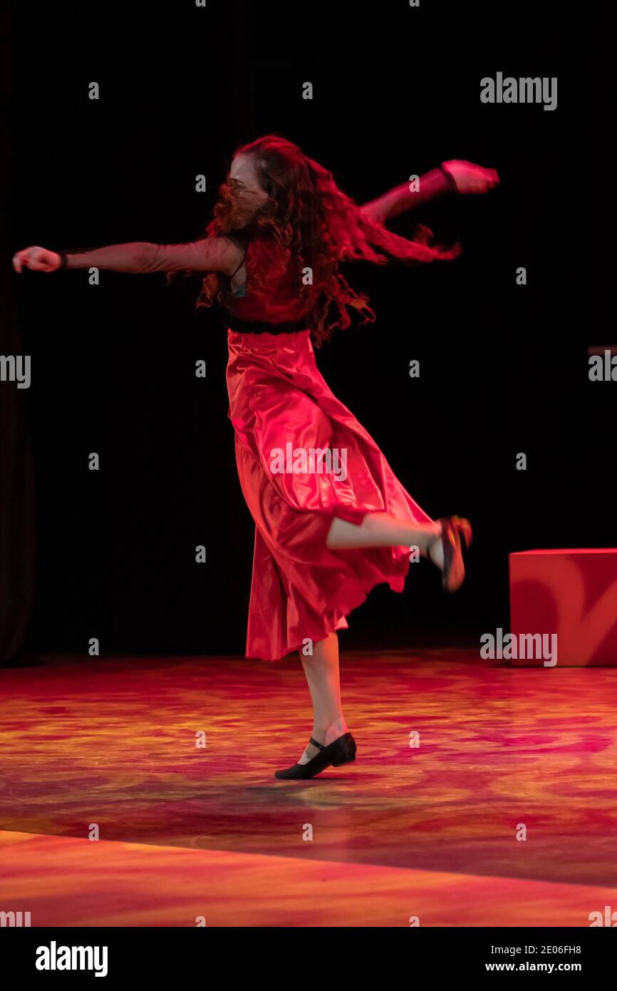 Dancer in a red dress dancing Spanish flamenco on the stage in the ...