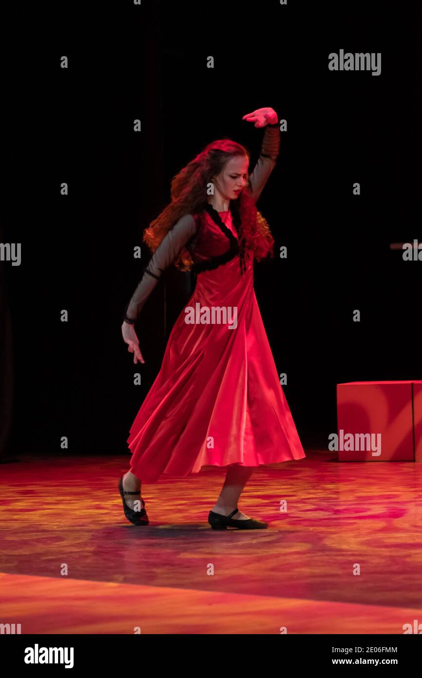 Dancer in a red dress dancing Spanish flamenco on the stage in the ...