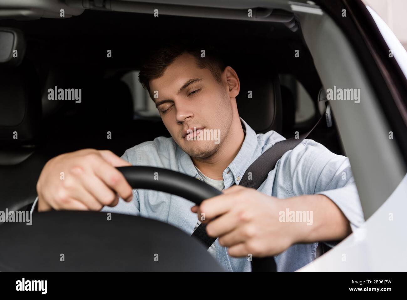 drunk man fall asleep while driving car, blurred foreground Stock Photo