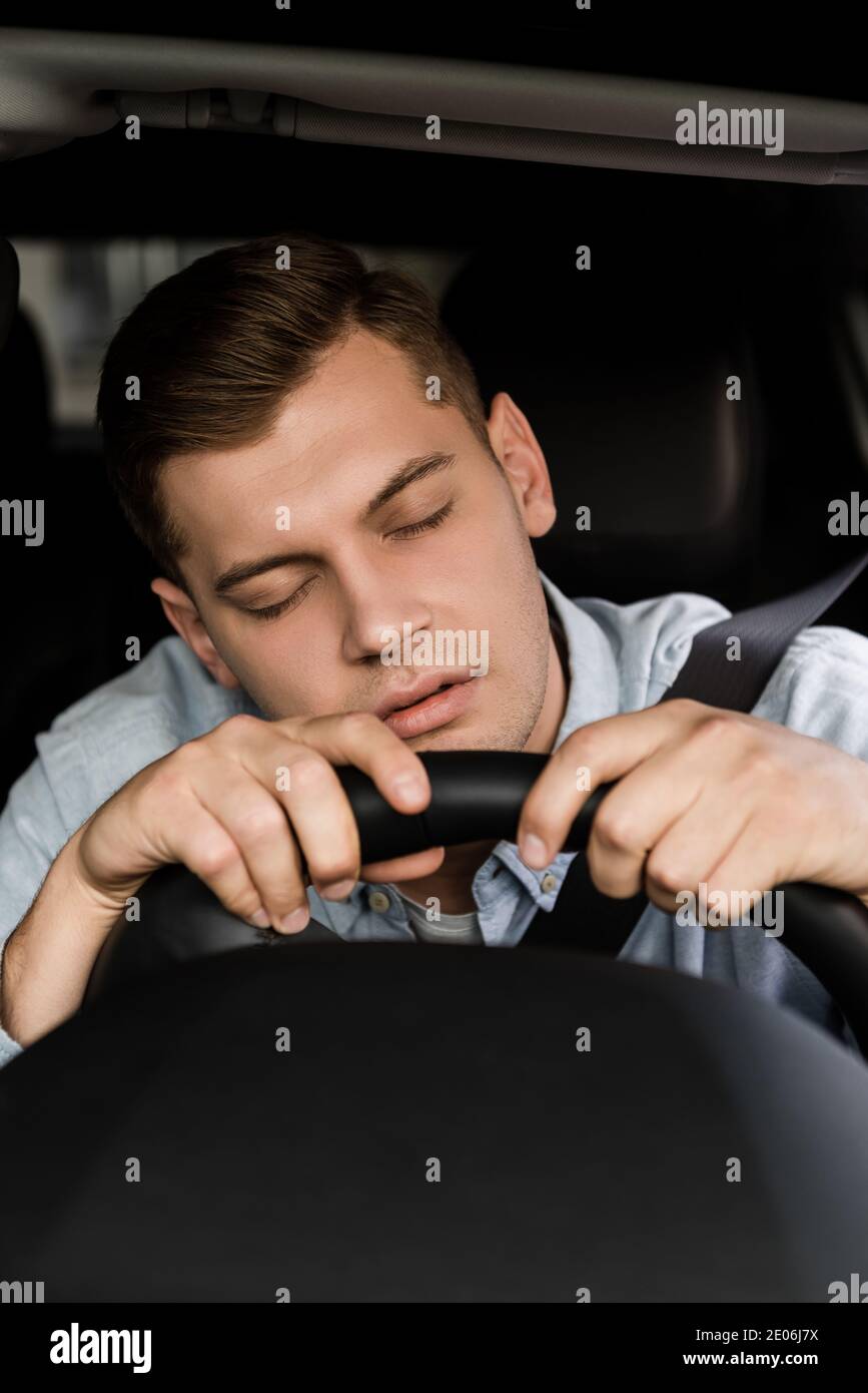 drunk man sleeping at steering wheel in car on blurred foreground Stock ...