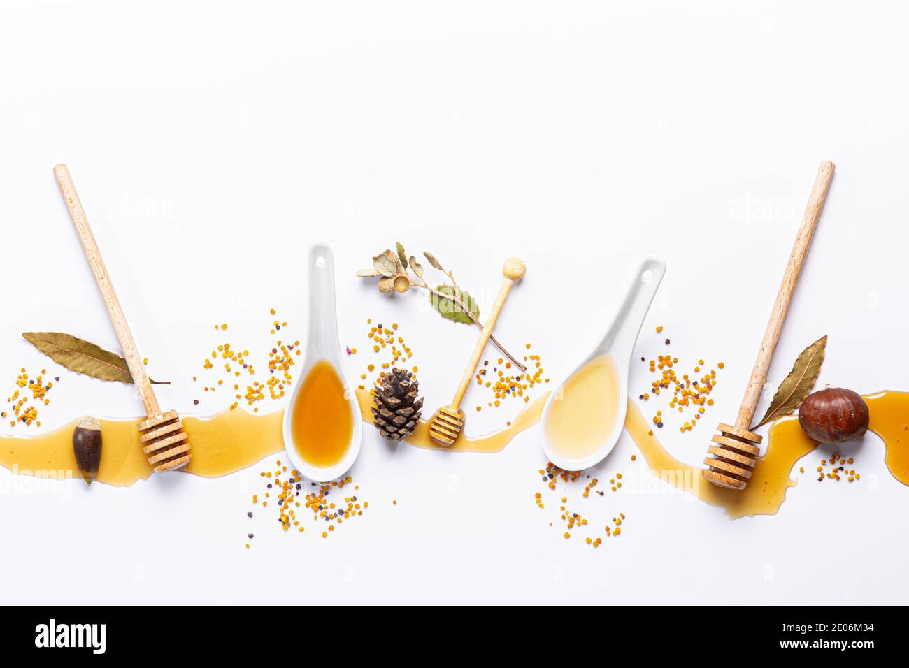 white spoons and honey sticks, with spilled honey, bee pollen isolated ...