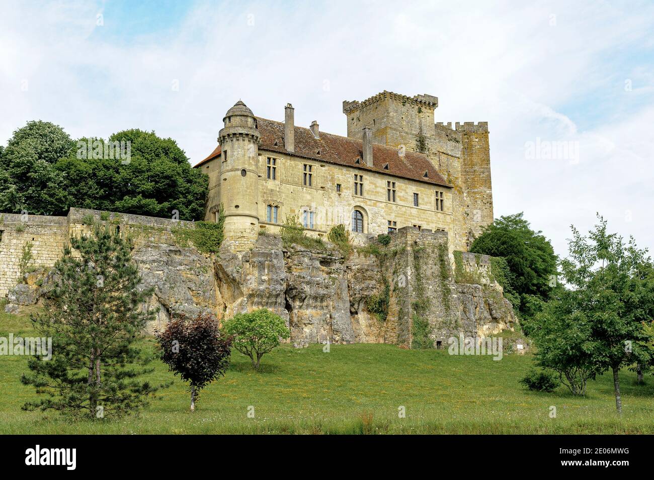 The castle of Excideuil, in the Périgord region of France, is perched on a rocky cliff. The yellow stone contrasts with the blue of the sky. Stock Photo