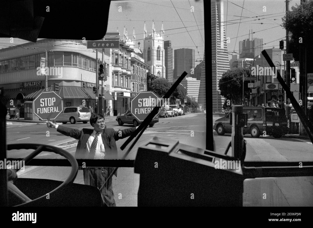 Funeral in progress man holding up a Stop Funeral sign, San Francisco California USA 1999. 1990s taken from inside of a Greyhound bus. HOMER SYKES Stock Photo