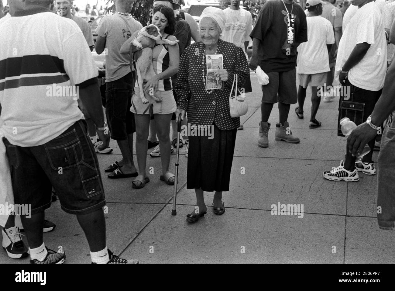 South Beach Ocean Drive, Miami Florida USA 1990s. An older senior woman with walking stick amongst a crowd of young African American men hanging out 1999 USA HOMER SYKES Stock Photo